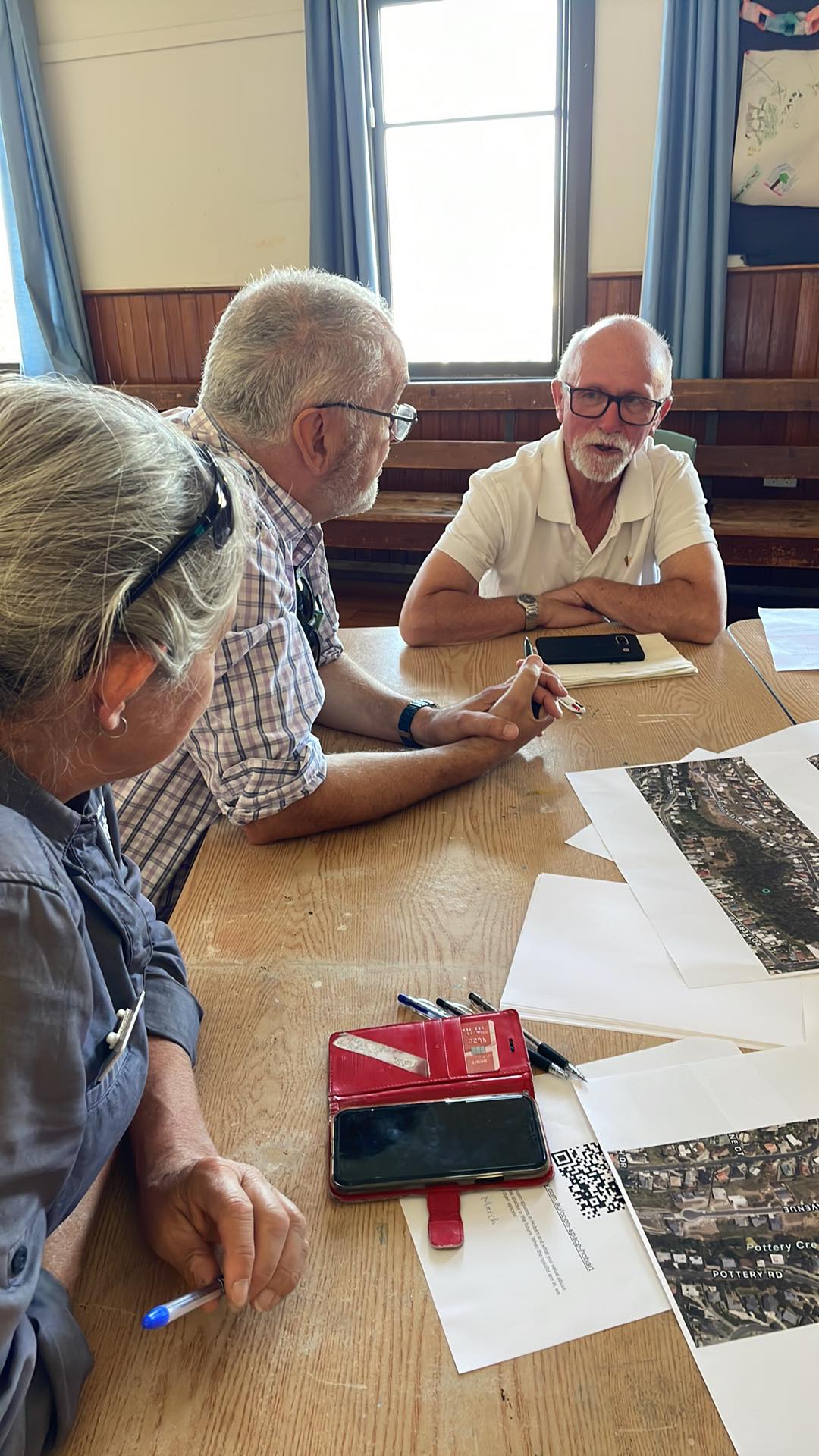 Three Lenah Valley community members and City of Hobart staff at a table discussing the Haldane Reserve.